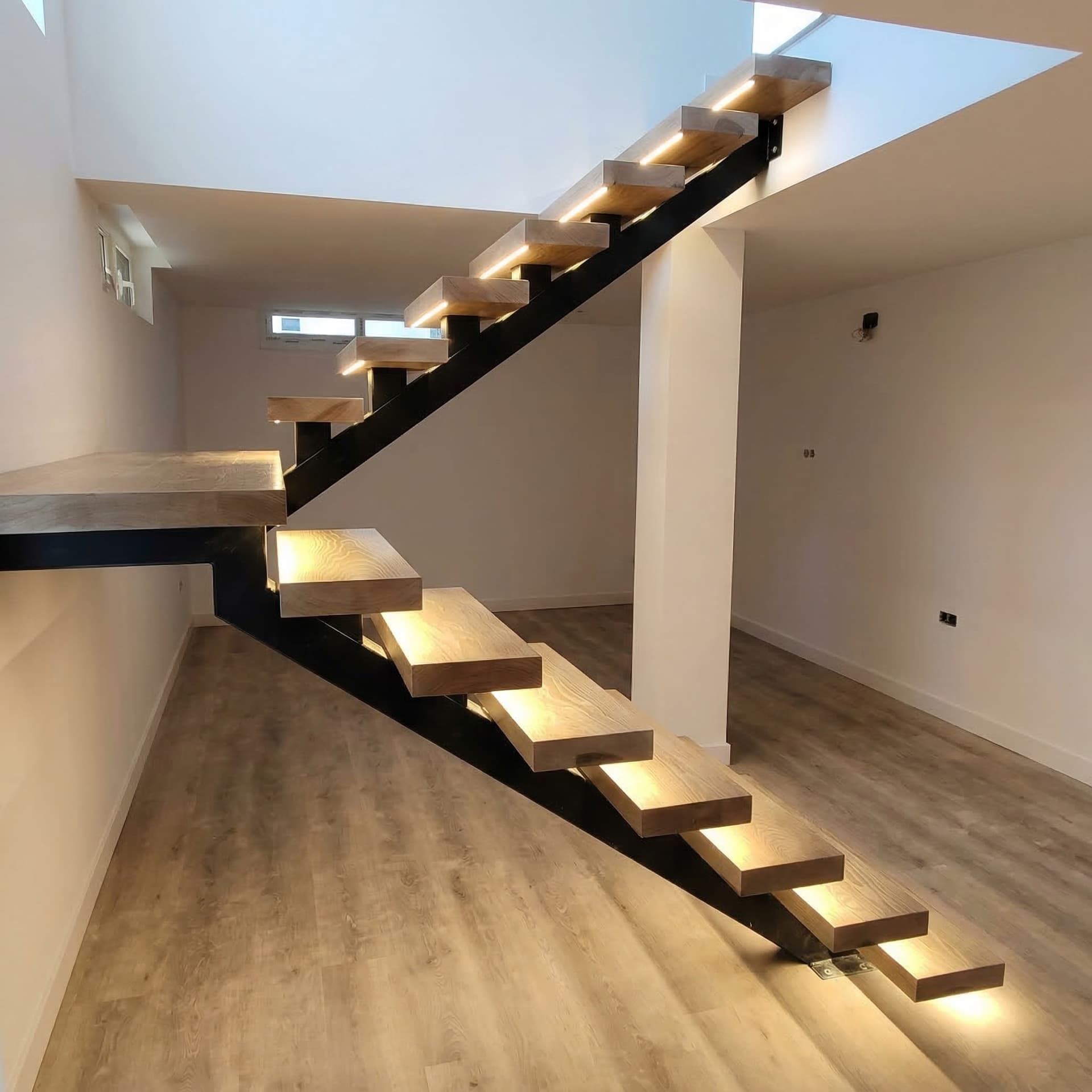 Forrado de escalera de estructura de hierro con peldaños de madera y luces LED con sensor.